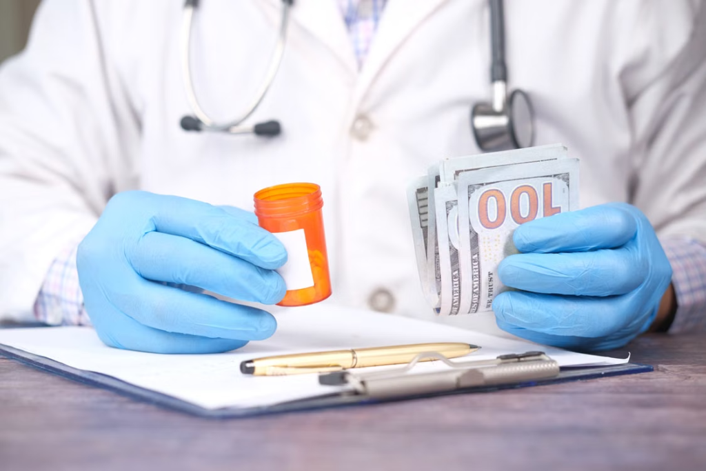 A person holding a container of medicines on top of a pen and a clipboard