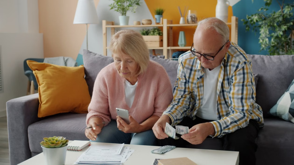An elderly couple checking documents and counting money