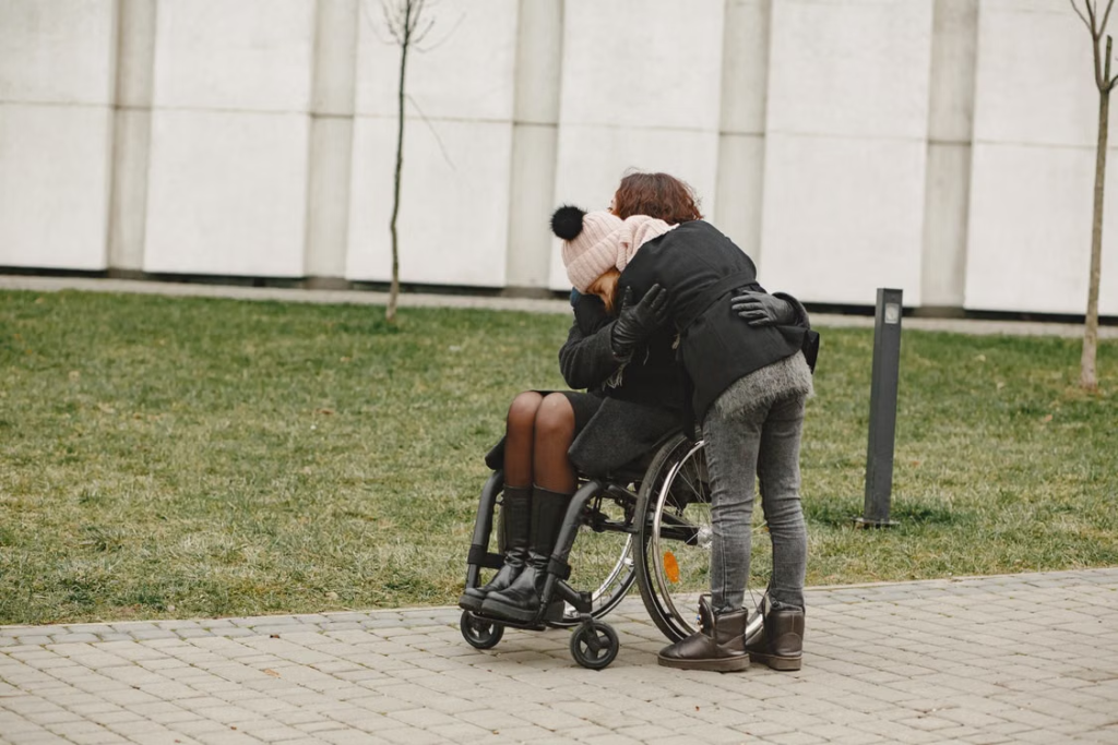  A person hugging another person in a wheelchair