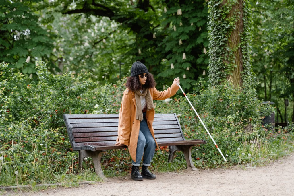  A person getting up from a bench using a cane 