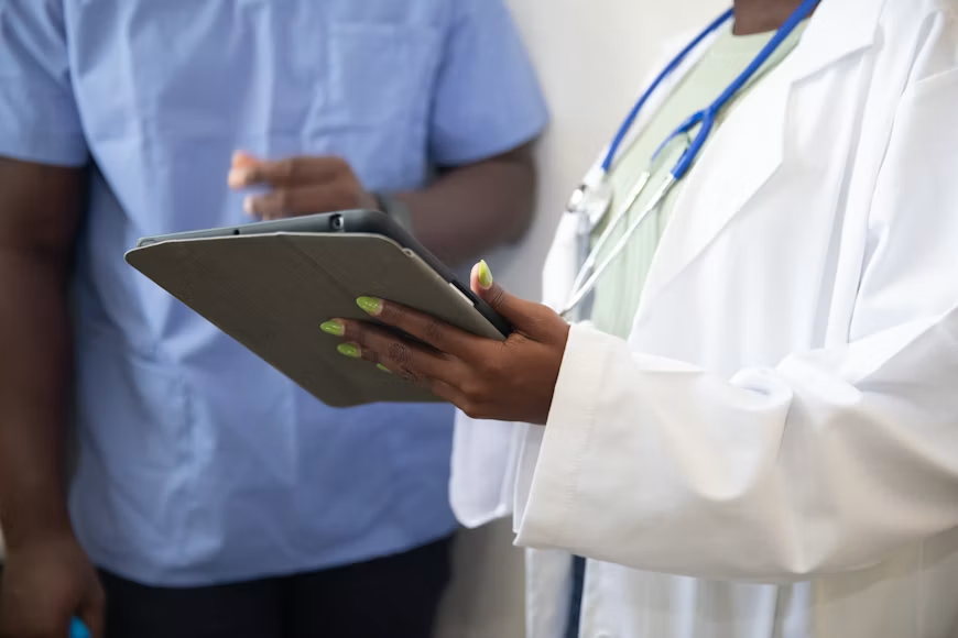 A healthcare professional showing another person their tablet
