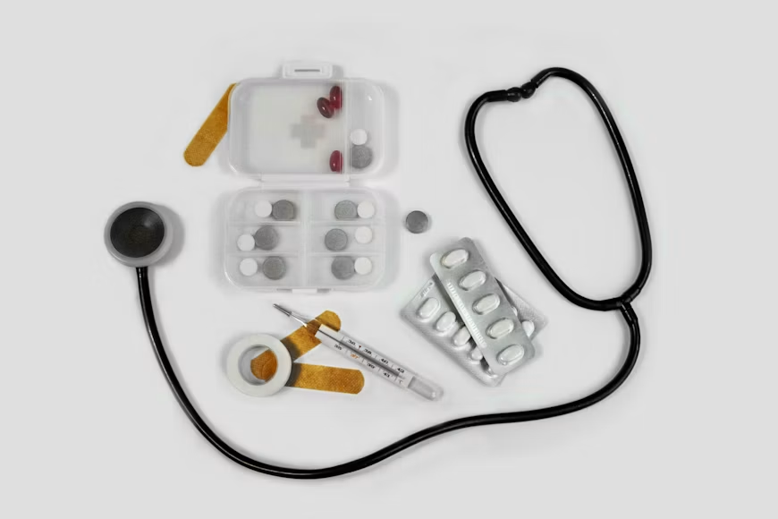 A stethoscope, thermometer, and medicines