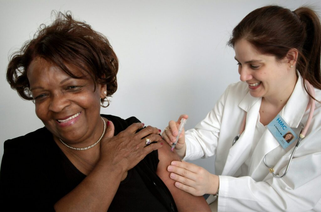 A nurse giving an injection in a woman's upper arm