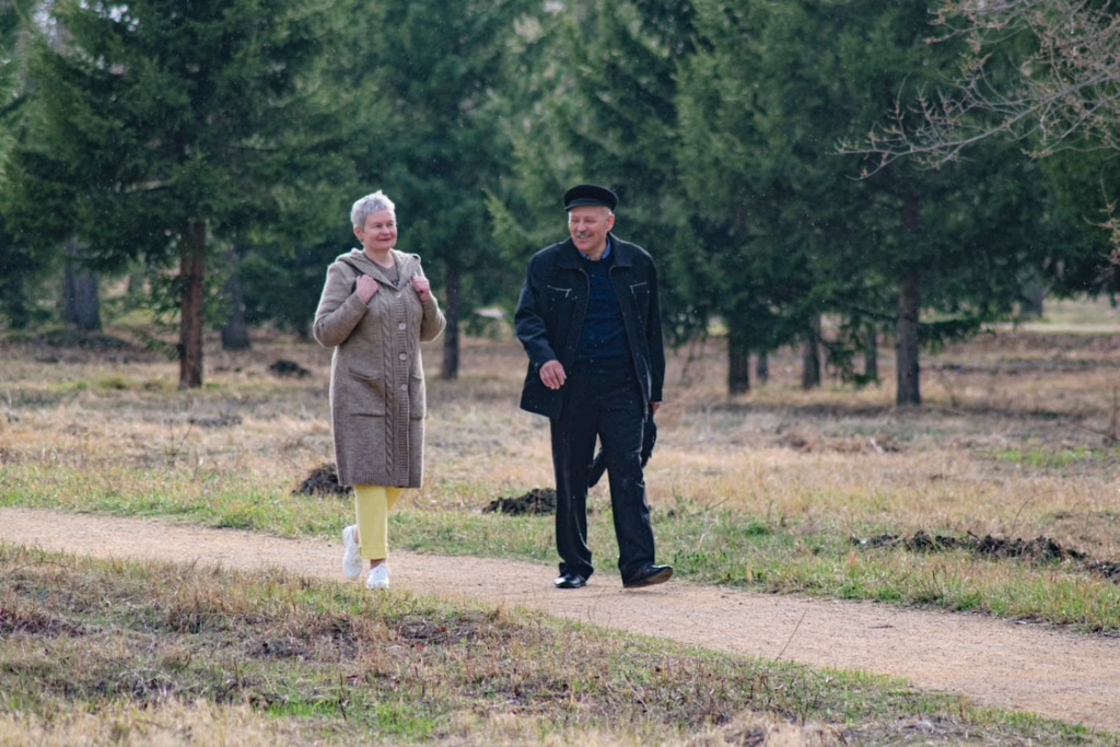 A senior couple walking together along a park path on a spring day